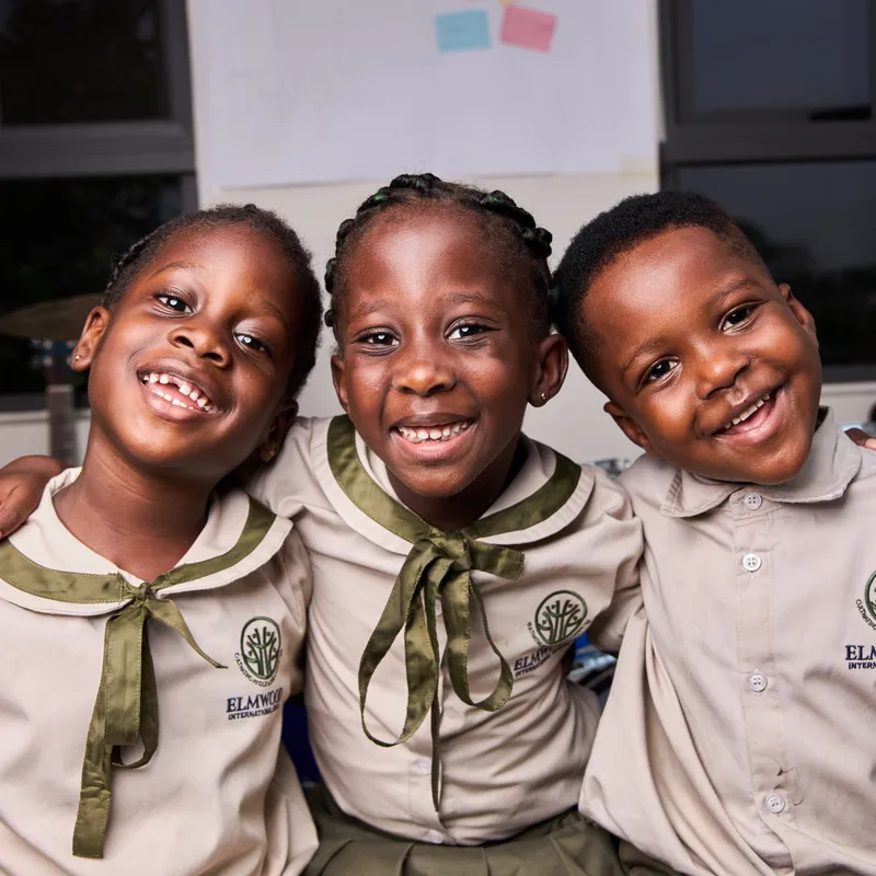 Happy students in Elmwood International School uniforms posing together