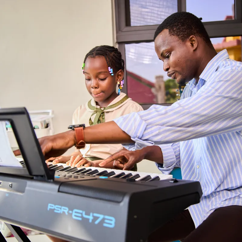 One-on-one music instruction at Elmwood International School featuring a student learning to play the piano.